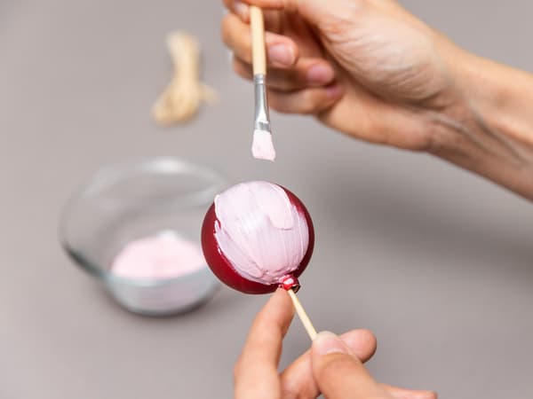 Die Farbe wird auf die Kugel aufgetragen.