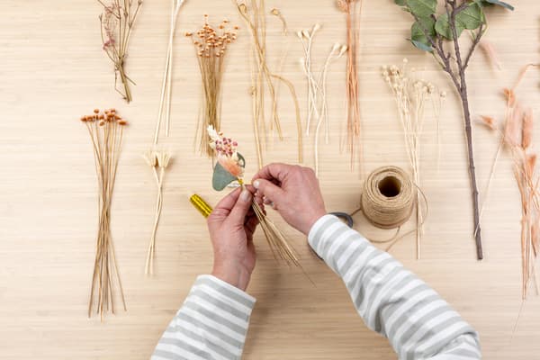 Die Hände halten das Sträußchen.