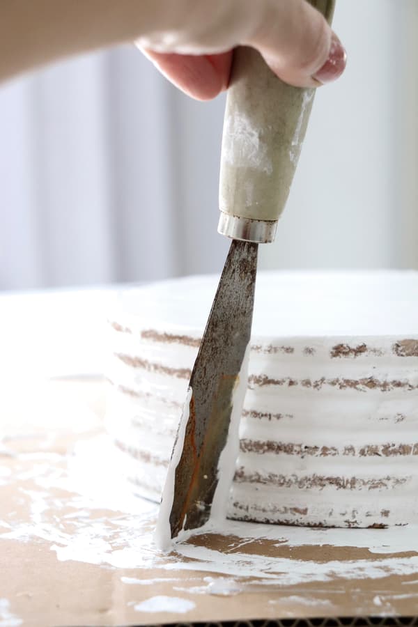 Die Korkplatten-Torte wird mit weißer Farbe bestrichen.