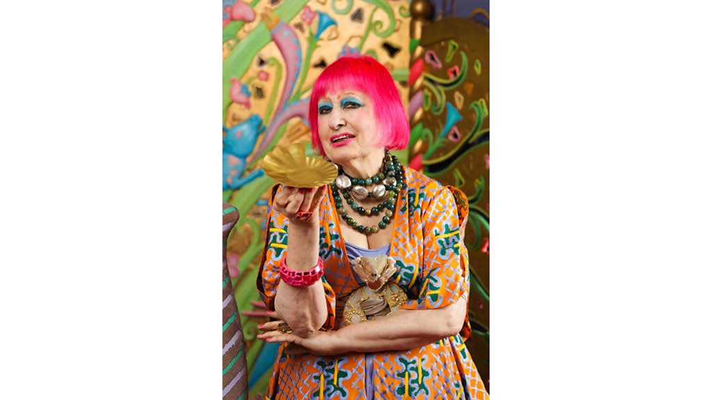 Die Textildesignerin Zandra Rhodes, die pinke Haare und auffälliger bunte Kleidun trägt.