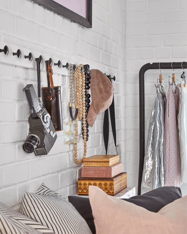 Die weiss lasierte LURT/ENERYDA Leiste mit Knöpfen mit Accessoires an einer Wand