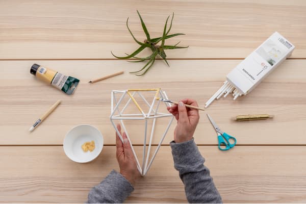 Die weißen Strohhalme werden mit goldener Farbe bemalt.