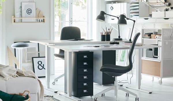Dieser in Weiss gehaltene Heimarbeitsplatz lässt sich bestens organisieren dank der Aufbewahrungslösung an der Wand, die aus IKEA EKBY Wandregalen und EKET Schränken in Weiss besteht. Und dann ist da noch das BEKANT Aufbewahrungselement mit Rollen mit weissem Netz. Hier lässt sich wirklich gut arbeiten.