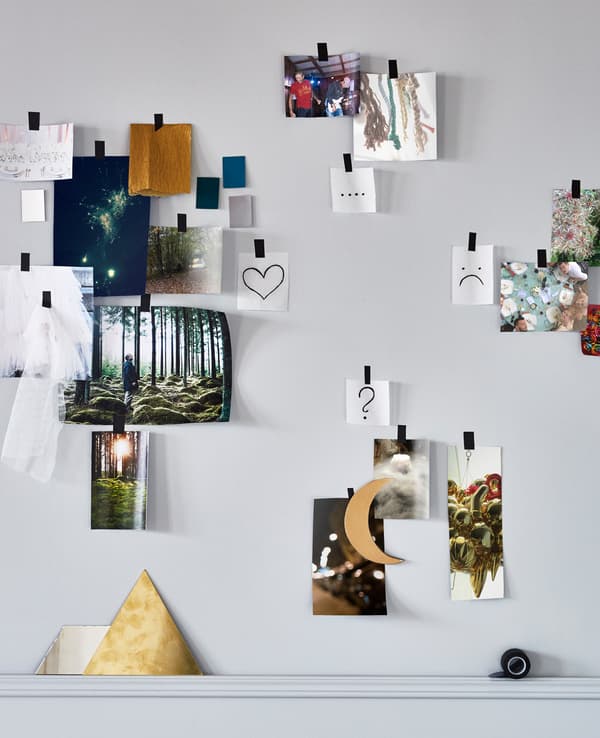 Different pictures of locations, foods, materials and colours taped to a wall and grouped by likes, dislikes and question marks to make a wedding moodboard 