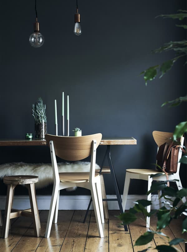 Dining chairs and table against a dark blue wall.