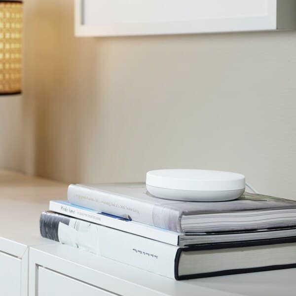 DIRIGERA hub for smart products from IKEA lying on a side table.