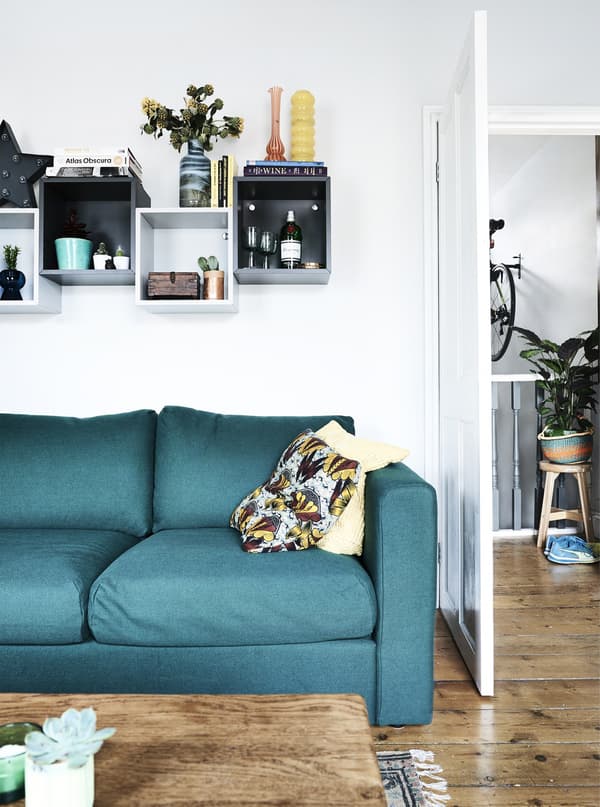 Display boxes above a green sofa.