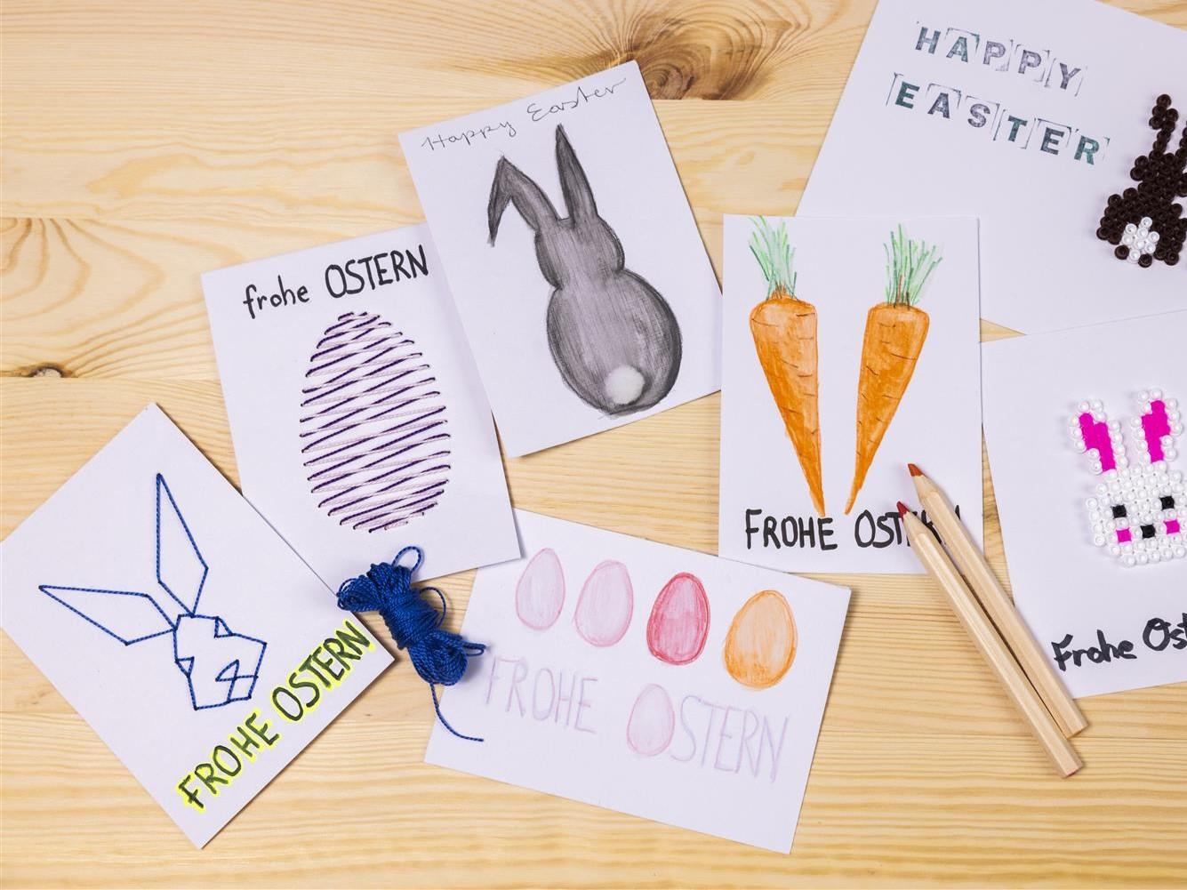 Diversi biglietti pasquali fatti a mano, realizzati con carta SOLFÅGEL e ricamati con motivi pasquali, disegnati a mano o decorati con perline da stiro. 