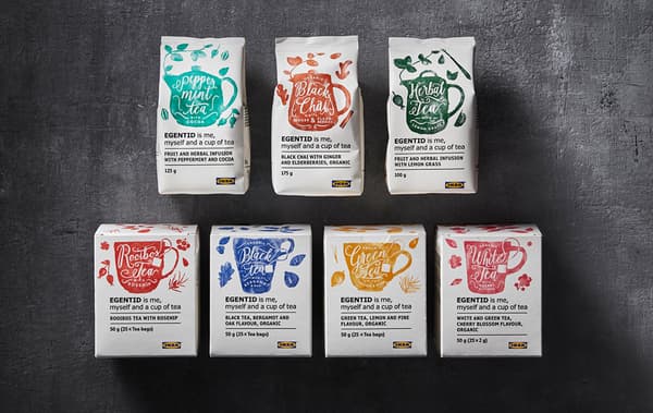 Diversi tipi di tè e tisane in confezioni bianche con illustrazioni colorate su uno sfondo scuro - IKEA