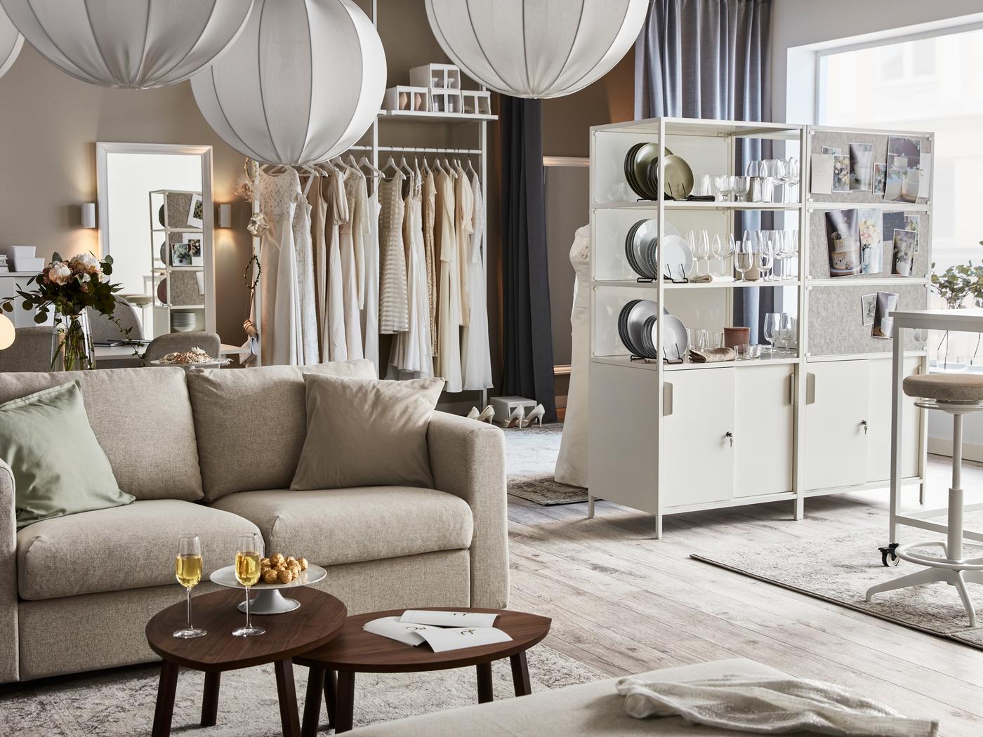 Divisão luminosa e arejada com sofá VIMLE, dois armários TROTTEN, candeeiros suspensos REGNSKUR agrupados e objetos decorativos.