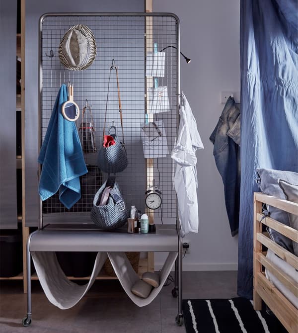 Divisor de cuarto VEBERÖD con algunhas toallas e bolsas colgando.