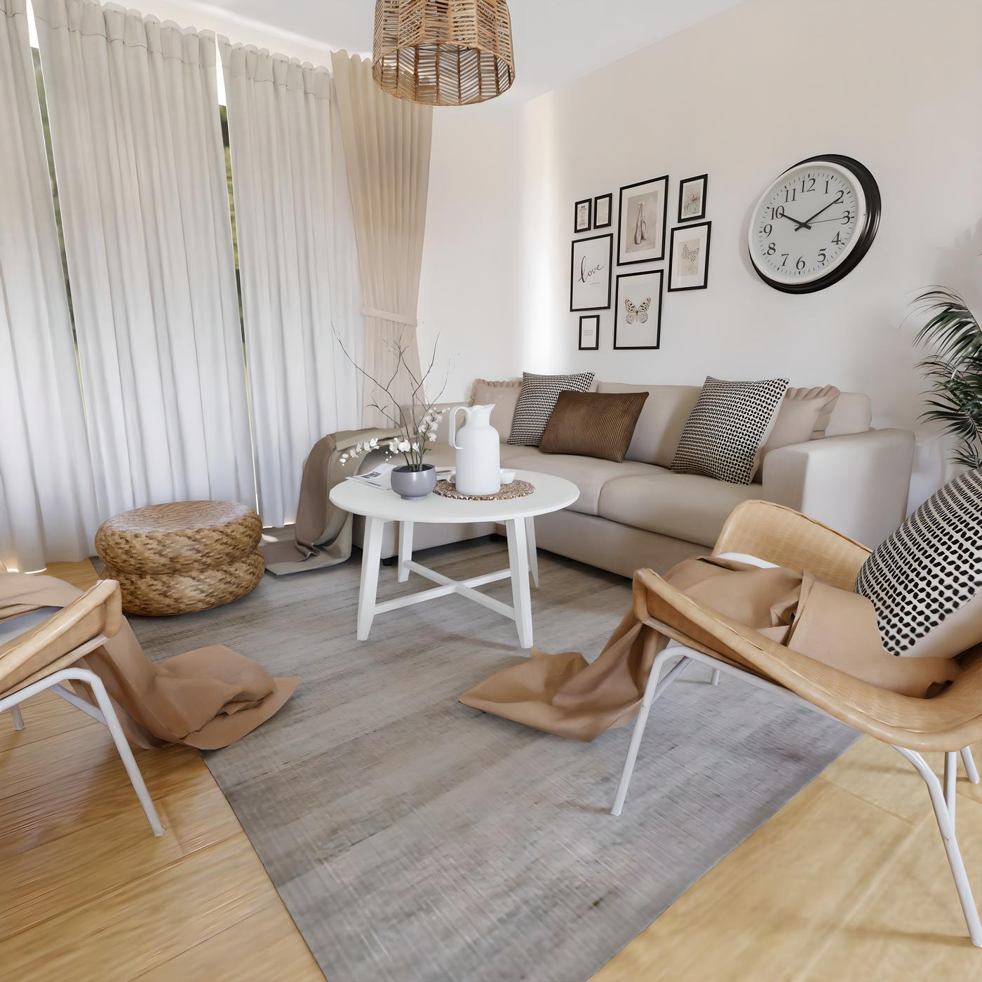 Dnevni boravak s bijelim zavjesama, sivim tepihom, bijelim stolom, dvije drvene stolice i kaučem. Na zidu su slike i sat.