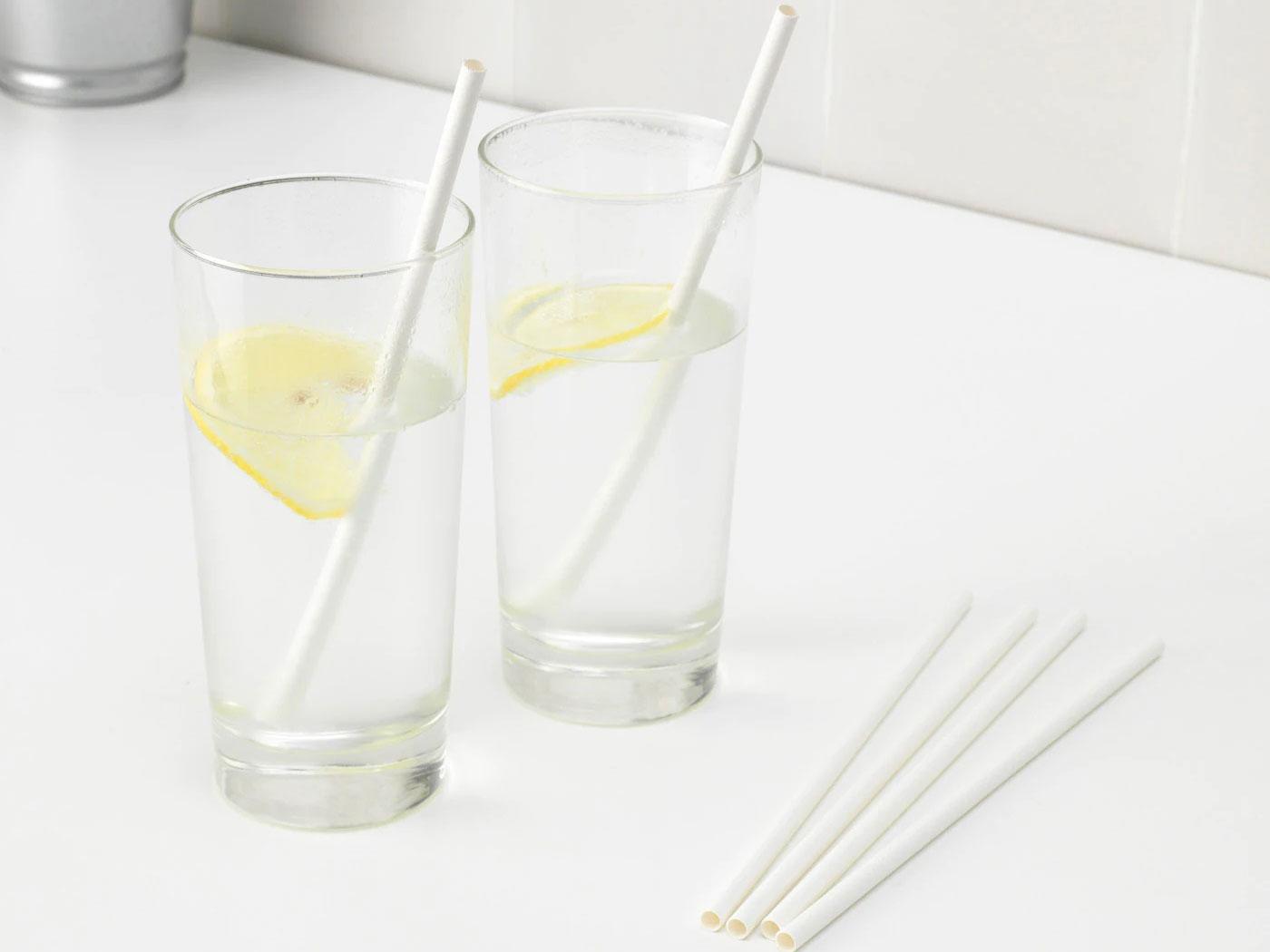 Dois copos transparentes com água e rodelas de limão com palhinha.