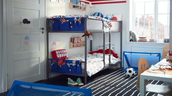 子ども部屋にあるTUFFING/トゥッフィング 2段ベッド。床には、サッカーボールと2個のゴール。 各ベッドの端にはブルーのポケット。