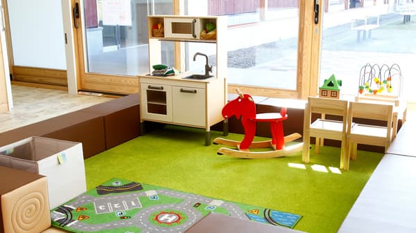 子どものプレイコーナー。ソフトな素材の囲いを作り、ラグを敷いて安全性を配慮。子どもたちが大好きなおもちゃがいっぱい。