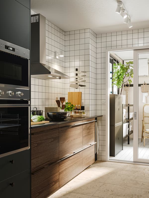 Donkerbruine keuken met witte tegels op de achtergrond