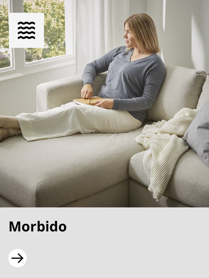 Donna sdraiata su un divano bianco angolare.