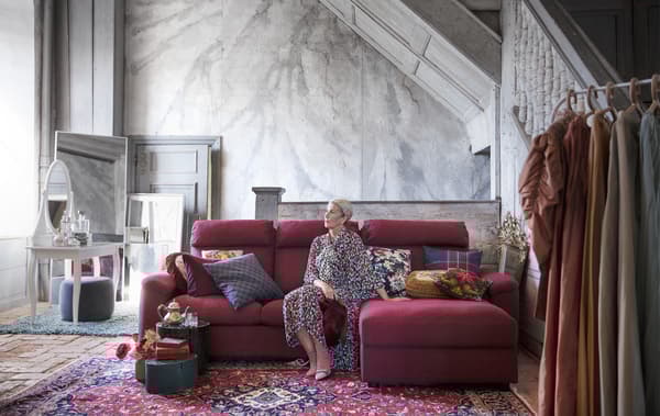 Donna seduta su un divano angolare in una stanza in marmo - IKEA