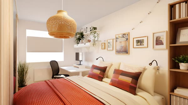Dormitor cald și cozy, cu pat în nuanțe crem, lenjerie și perne colorate, lampă din ratan, galerie de rame foto pe perete, birou cu scaun și plante verzi, perfect pentru relaxare și lucru de acasă.