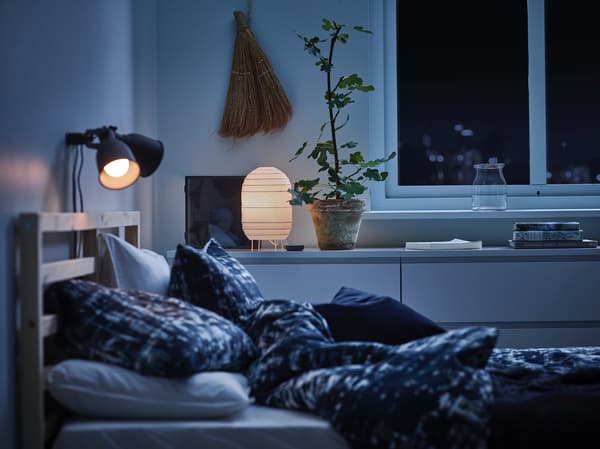 Dormitorio con lámpadas de noite acendidas e persianas subidas.