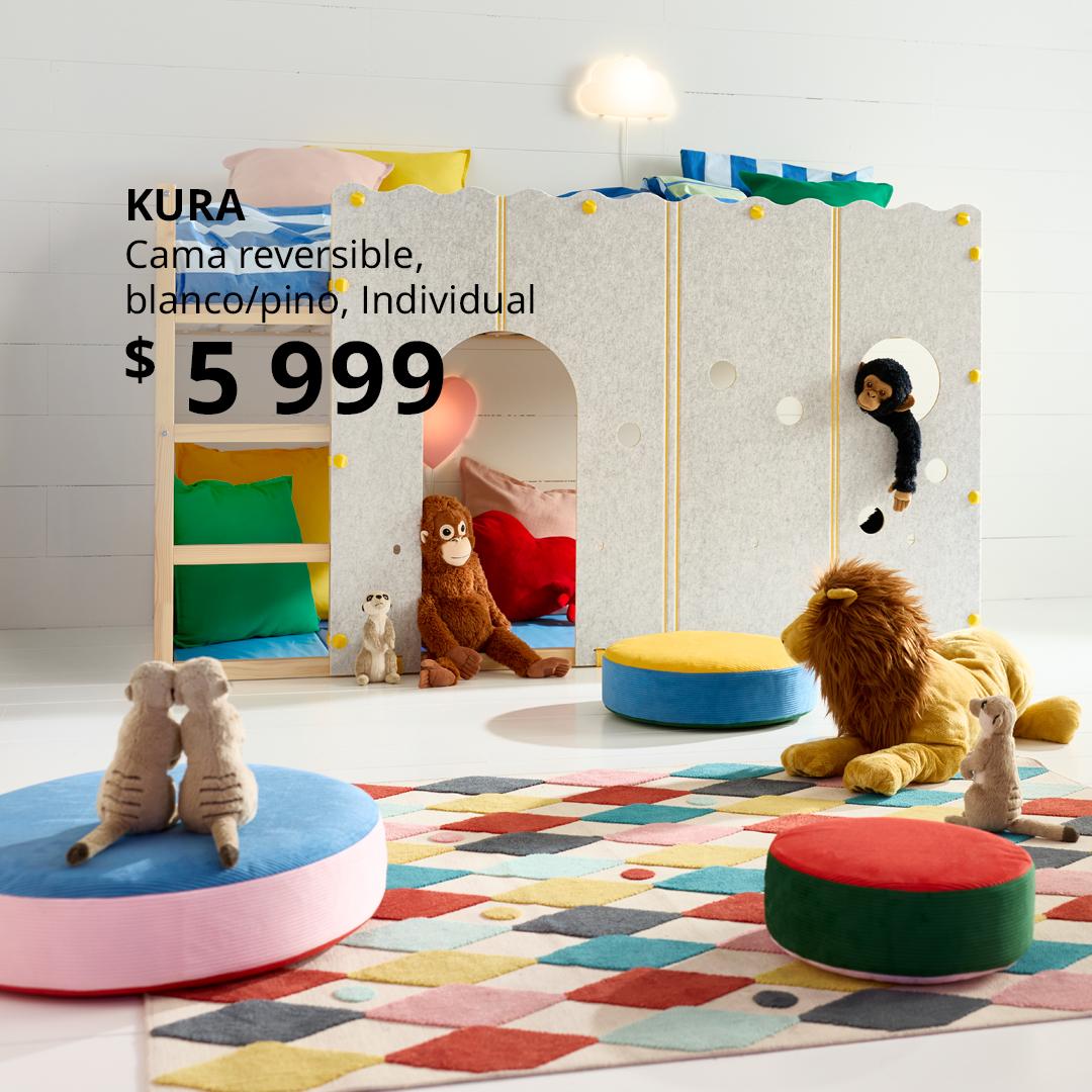Dormitorio infantil con cama reversible KURA de madera clara y panel frontal con accesorios decorativos, espacio inferior tipo casita para jugar, peluches y cojines coloridos sobre alfombra geométrica; diseño versátil, seguro y divertido para niños.