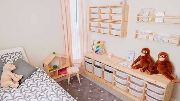 Dormitorio infantil con TROFAST para almacenar juguetes, repisas y peluches de monos.