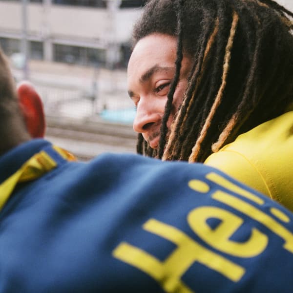 Dos col·laboradors d'IKEA, un amb rastes, que estan inclinats cap endavant mentre xerren.