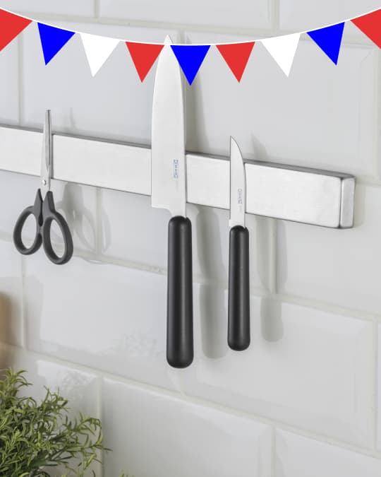 dos cuchillos sostenidos por unimán en la pared de una cocina.