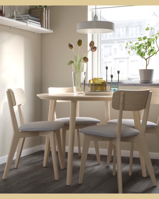 Dos sillas de comedor con marco de madera y asiento tapizadocon na mesa redonda.