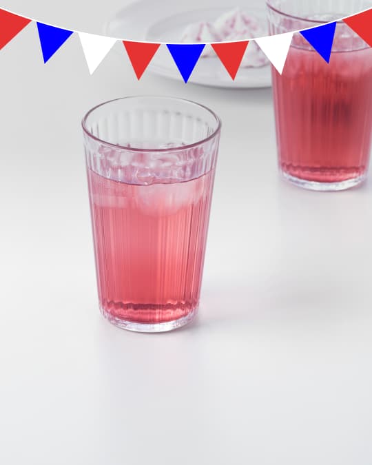 Dos vasos de vidrio con un líquido rojo sobre una mesa.