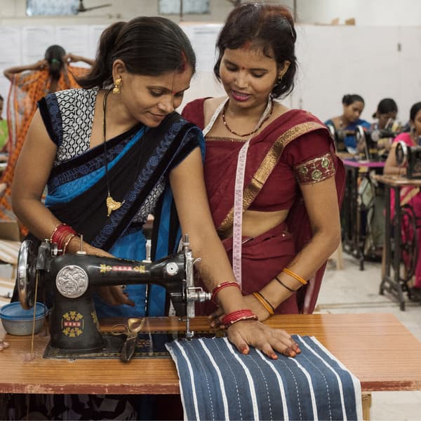 Două femei se bucură de un tutorial privind cusutul în cadrul inițiativei IKEA  de Ziua Internațională a Femeii din India.