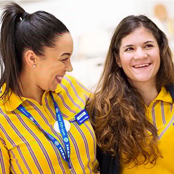 Două persoane cu uniforme galbene cu albastru, stând una lângă alta.