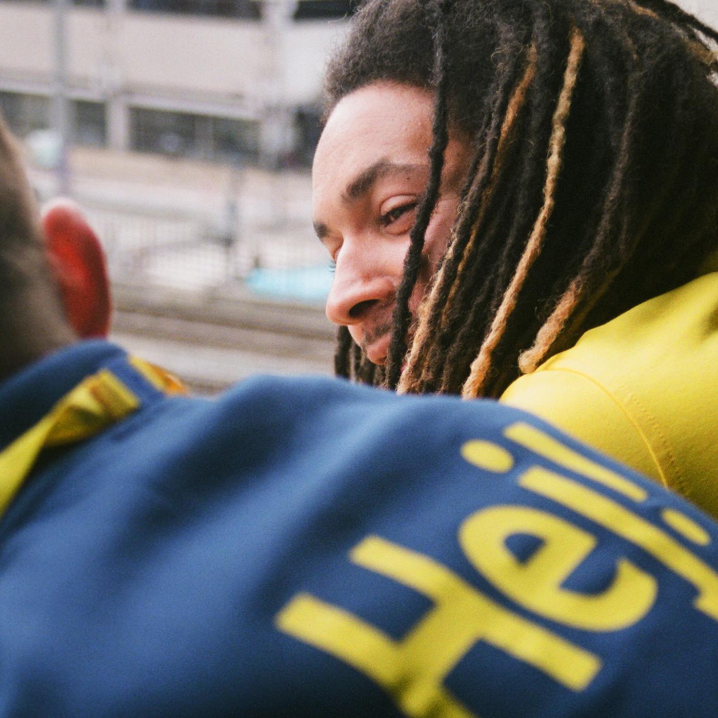 Dous colaboradores/as de IKEA, un con rastas, inclinados cara adiante e parolando.