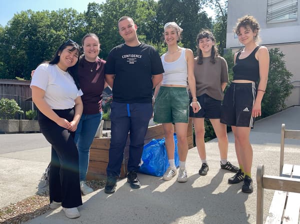 Drei IKEA Mitarbeiter:innen stehen gemeinsam mit 3 Schülerinnen von der HTL Spengergasse vor einer Caritas Einrichtung.