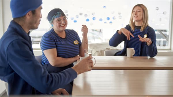drei IKEA Restaurant Mitarbeiter die sich amüsiert Unterhalten