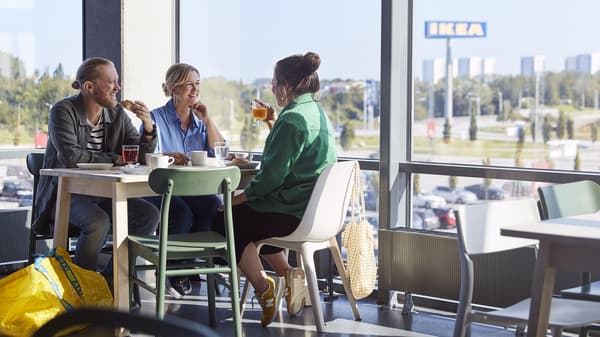 Drei Menschen sitzen essend im IKEA Restaurant.