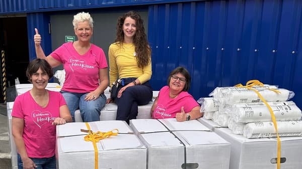 Drei Mitglieder des Eschborner HerzKissen e.V. gemeinsam mit einer IKEA Mitarbeiterin. Sie stehen vor großen Kartons und Paketen, die die Spende von 200 IKEA Kissen enthalten. Diese werden für die Herstellung der Herzkissen genutzt. Gemeinsam entstehen Herzensprojekte.