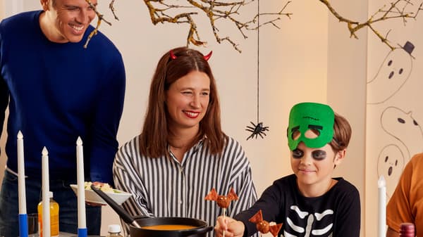 Drei Personen sind an einem Tisch und sind im Halloween-Stil verkleidet.