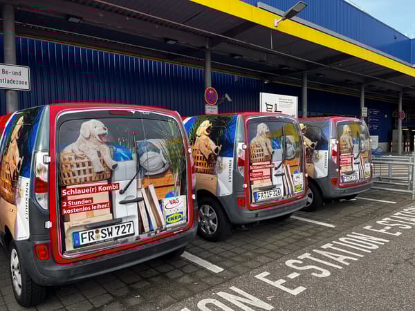 Drei rote Elektrofahrzeuge, die mit IKEA Produkten und dem Logo bedruckt sind.