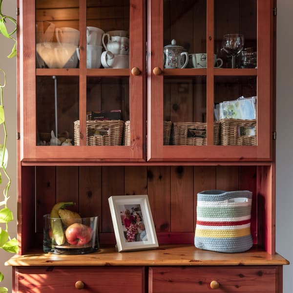 Drewniany kredens z blatem, na którym stoi torba STRANDSKATA.