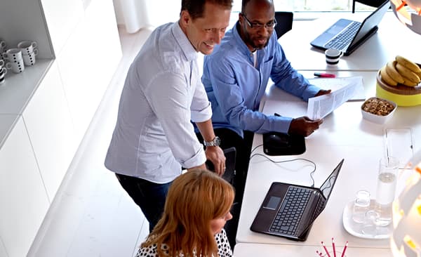 Drie IKEA medewerkers aan het werk met laptop