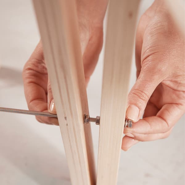 Drill a small hole, in one leg only, 20 cm high, on two of the three stools.
