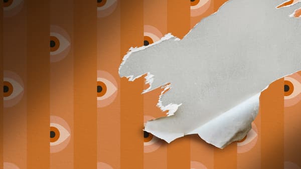 Dryžuoti oranžinės spalvos tapetai su subtiliais akių raštais, vienoje vietoje įplyšę, simbolizuojant smurtą artimoje aplinkoje ir įtampą.