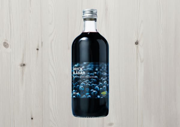 Du sirop de bleuets DRYCK BLÅBÄR et du bois en arrière-plan.
