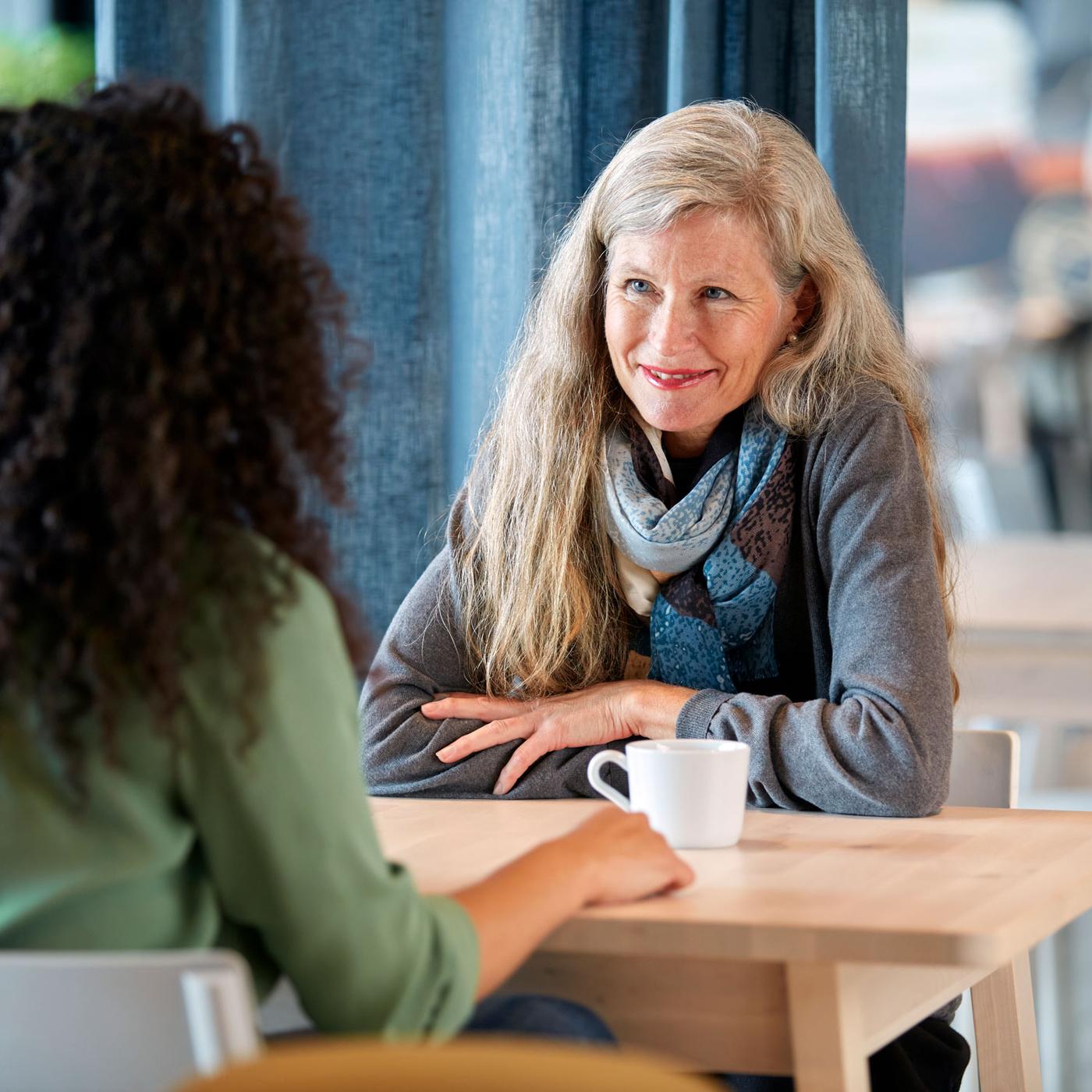 Duas mulheres a conversar à mesa