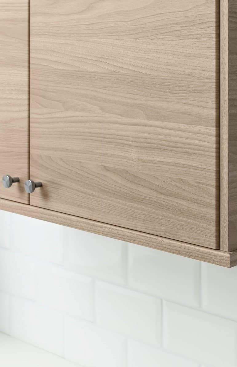 Due ante di un mobile beige con dei pomelli.