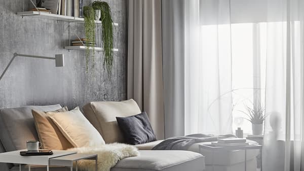 Due chaise-longue KIVIK vicino a una grande finestra con diversi strati di tende, tra cui tende oscuranti HILLEBORG - IKEA