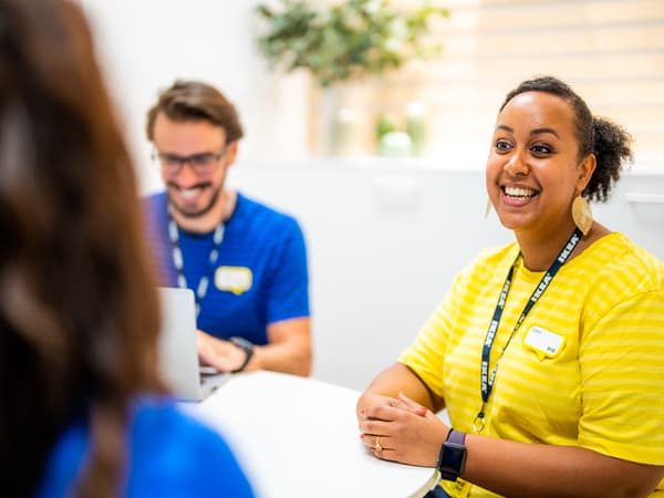 Due co-worker IKEA che indossano l’uniforme di IKEA bevono una tazza di caffè insieme in mensa
