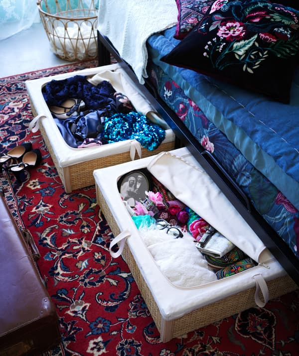 Due contenitori sottoletto RÖMSKOG aperti contententi alcuni oggetti e indumenti.