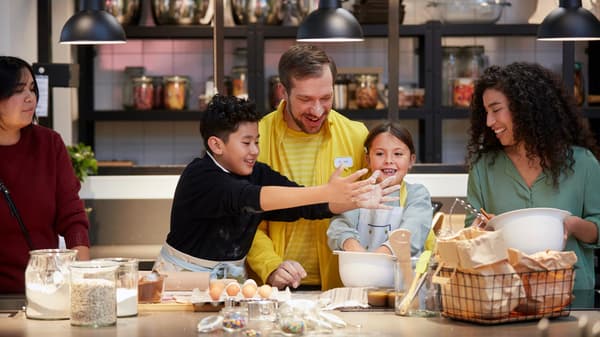 Due donne e due bambini partecipano a un evento in negozio e ridono insieme a un co-worker IKEA.